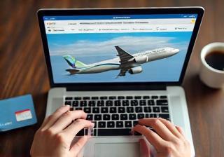 Person booking flights on a laptop with a credit card